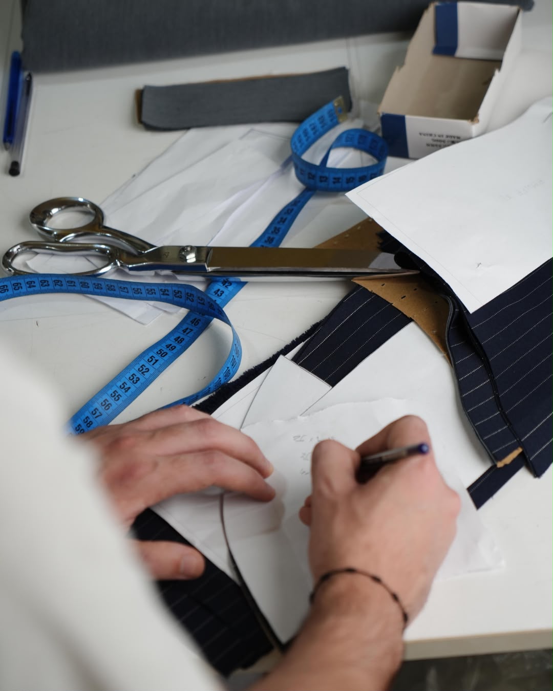 Shears, a tape measure and paper patterns on the cutting table